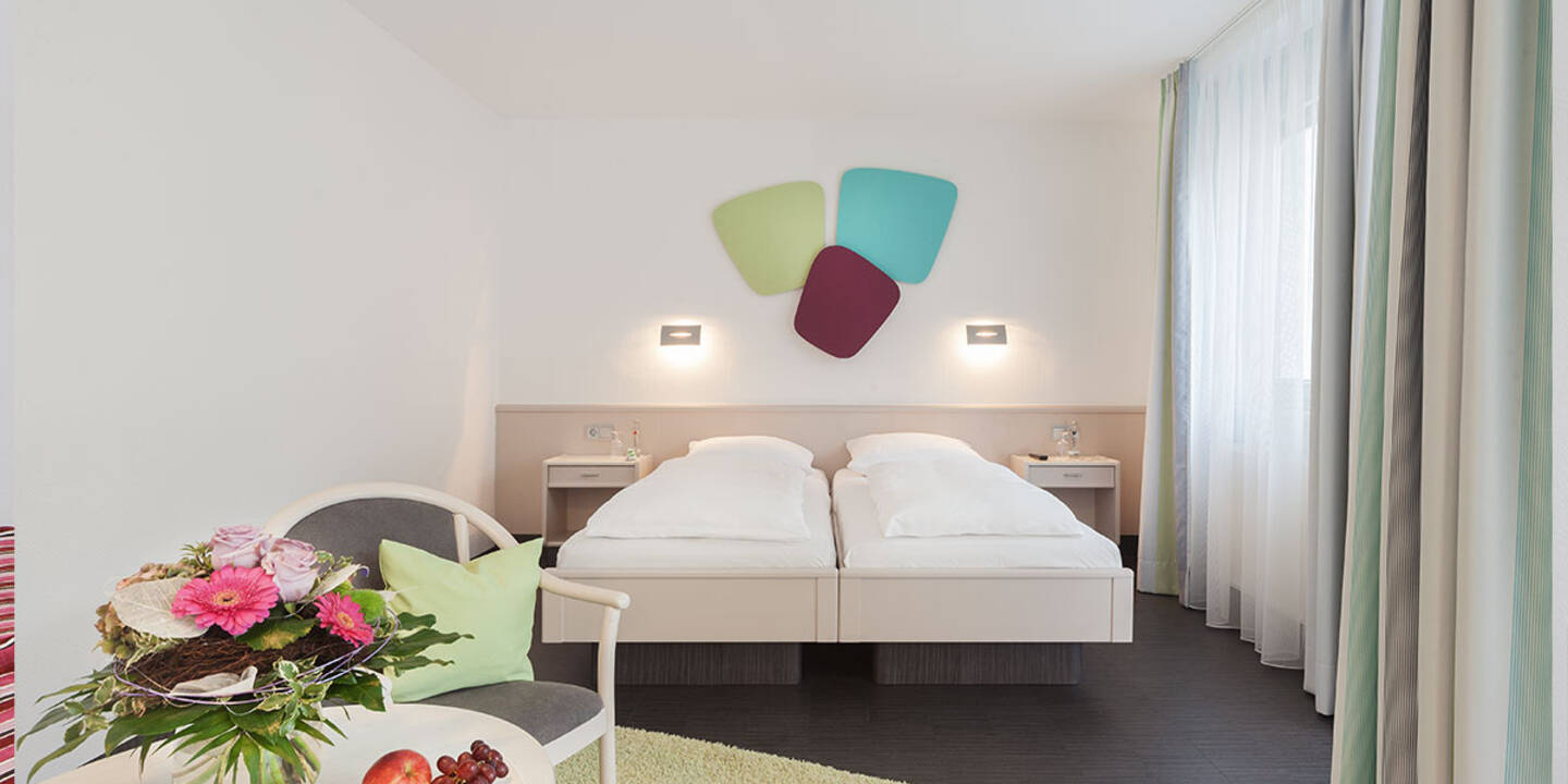 Ausstattung eines modernen Hotelzimmers im Akazienhaus Herzogspark mit Bett und Bad